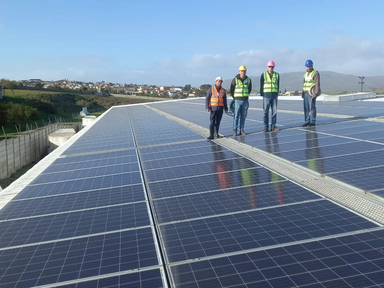 Tygerdal Electrical team standing on a large commercial rooftop solar array