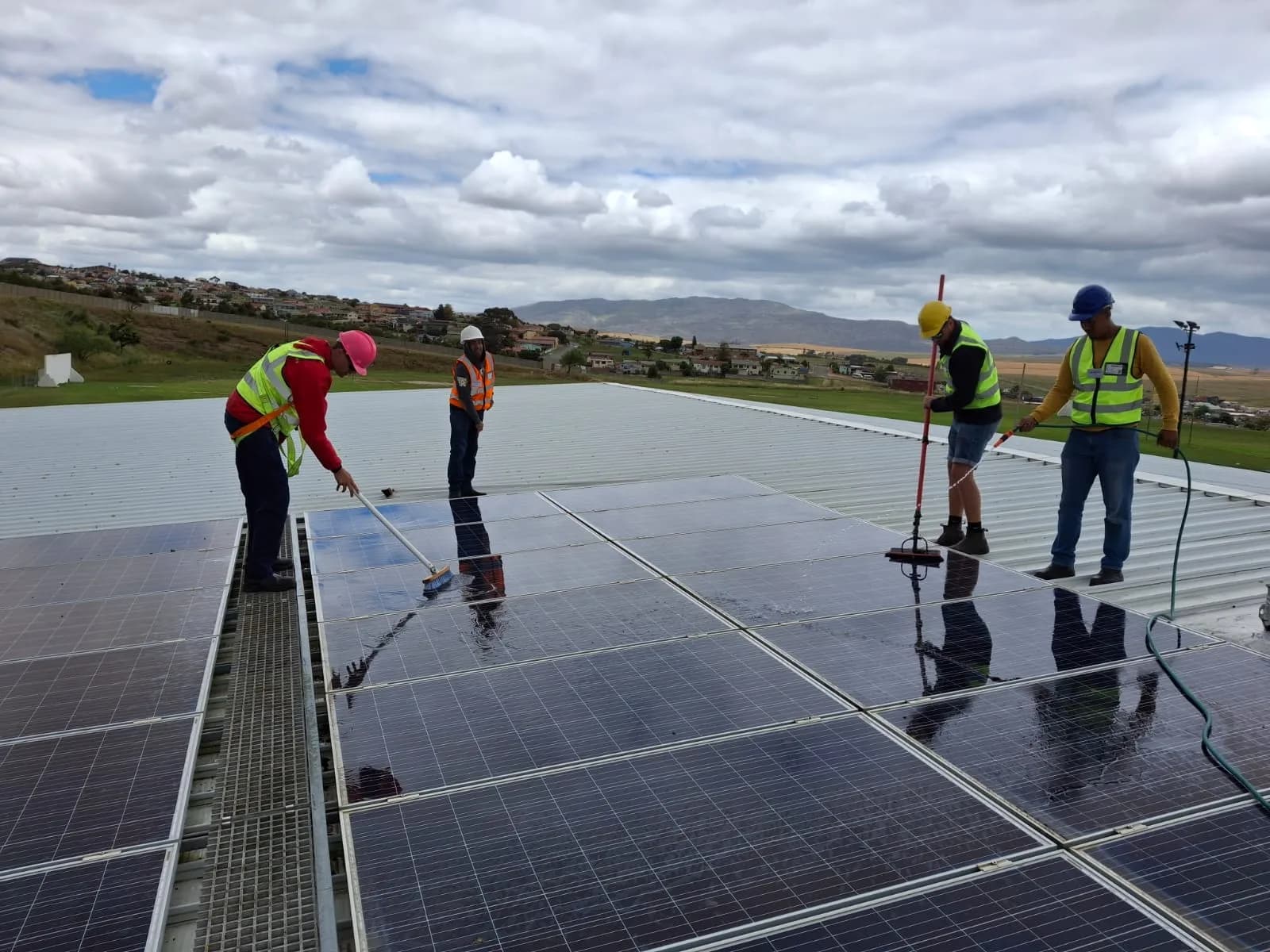 Tygerdal Electrical technicians cleaning a large commercial rooftop solar array in Cape Town
